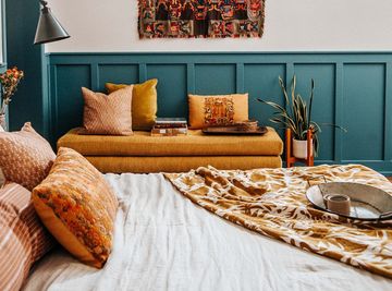 bedroom, bed, yellow cushioned bench, tapestry on wall