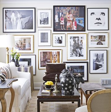 a gallery wall in the living room showcases some of alessandro uzielli's photography collection coffee table, vaughan side table, minton spidell the striped chair is a paris flea market find