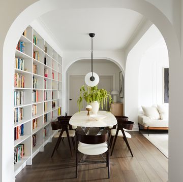 home library in brooklyn apartment designed by space exploration featuring a wall of books framed by arches