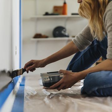 woman sitting painting wall at home